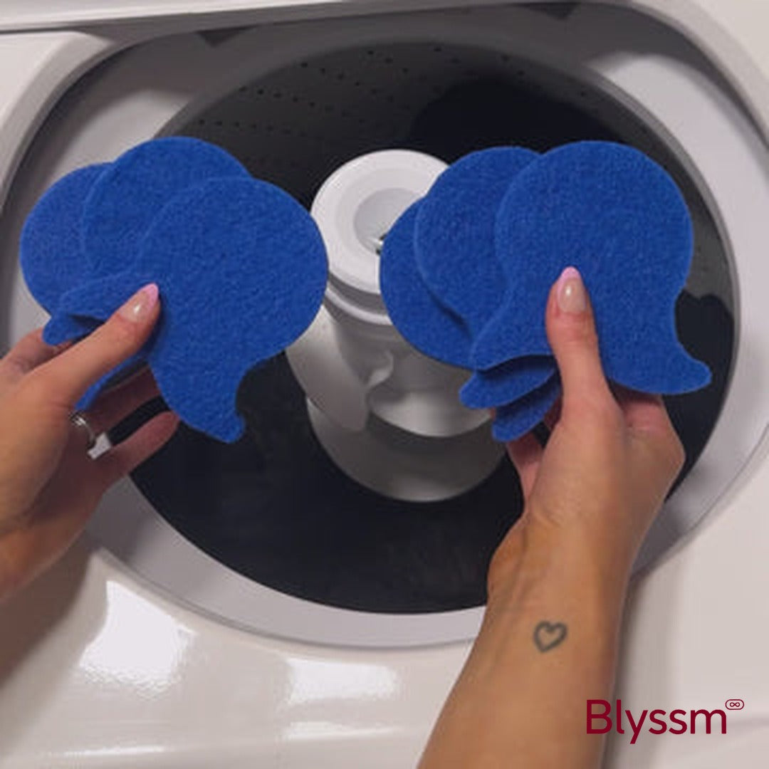 Two hands holding stacks of blue Blyssm Laundry Fur Catcher pads over an open top-load washer