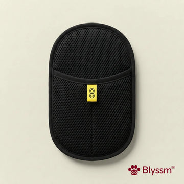 Blyssm Deshedding Grooming Glove, black mesh mitt with yellow Blyssm tab, flat lay on cream background