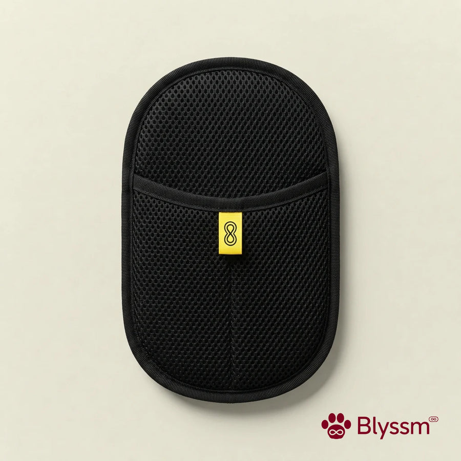 Blyssm Deshedding Grooming Glove, black mesh mitt with yellow Blyssm tab, flat lay on cream background